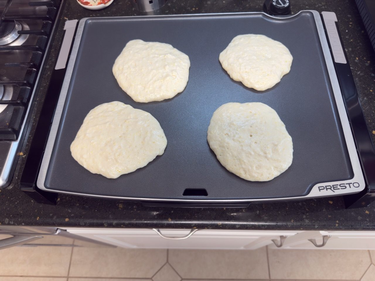 Four 8 in pancakes on griddle